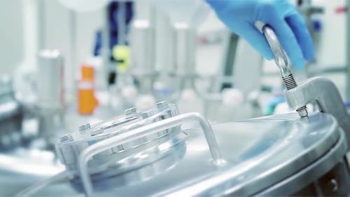 Un scientifique ouvre un réservoir en aluminium stérile dans un laboratoire de l'industrie chimique. 4K.