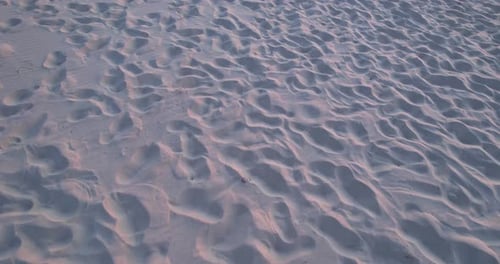 Footprints in the White Sand Sandy Beach By the Sea at Sunset