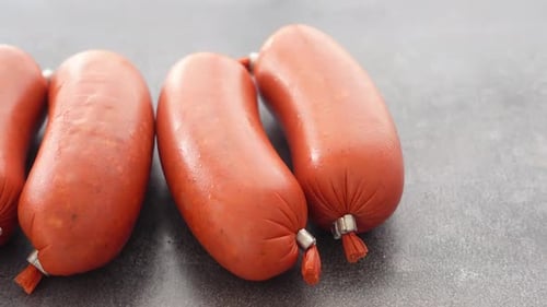 Juicy Sausages Lying on a Gray Table