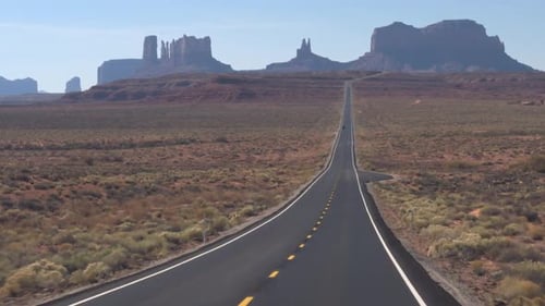 Scenic Empty Road Stretching Toward Red Rock Buttes In Arizona