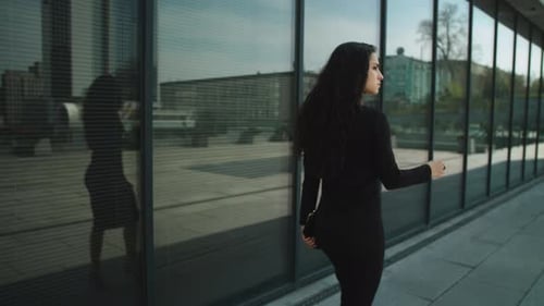 Confident young businesswoman walking down a luxury street in the city