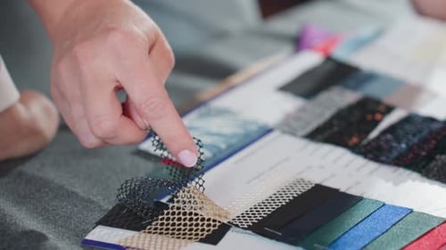 Close Up of Hand Selecting Colorful Net and Lace Material Samples for Fashion Design