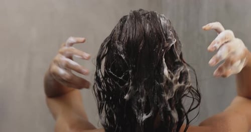 Back View of Naked Woman Washing Hair With Shampoo While Taking a Shower