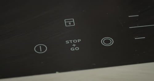 Finger Adjusting Temperature on Induction Cooktop