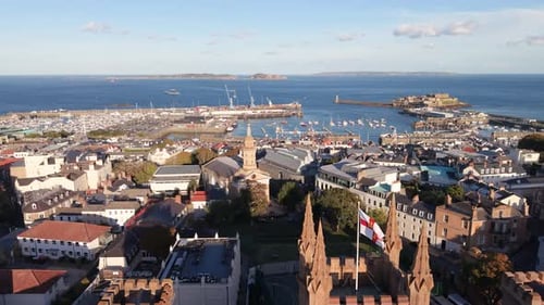 Flight over Elizabeth College St James and rooftops of St Peter Port Guernsey towards harbour Herm