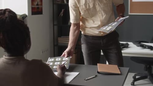 Instructor Reviews Documents With Students In Office