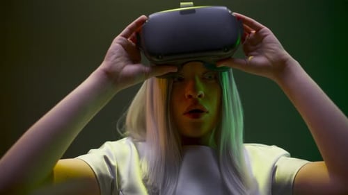 Woman Taking Off VR Headset in Studio Lighting