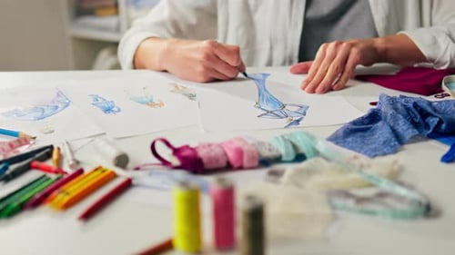 Artist Drawing Fashion Designs at Desk