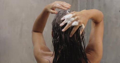 Back View of Naked Woman Washing Hair With Shampoo While Taking a Shower