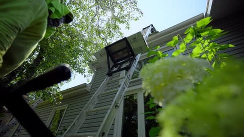 Roofer Installing a New Roof on an House Using Special Lifting Devices Close Up