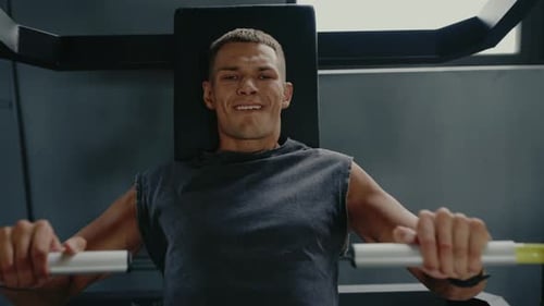 Young Man Exercising on Gym Equipment for Strength Training and Fitness