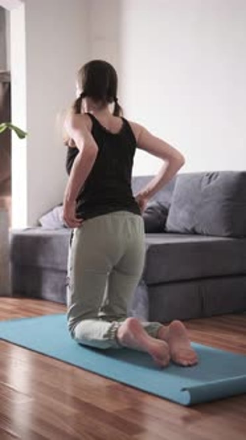 Femme en chameau posant sur un tapis de yoga pratiquant le backbend pour la flexibilité de la colonne vertébrale et l'ouverture de la poitrine à la maison