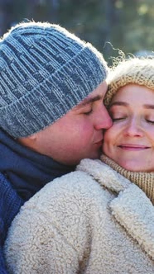 Das Paar umarmt sich herzlich, während es einen Wintertag im Freien genießt