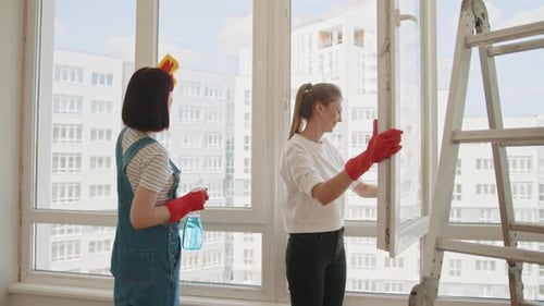 Ein Mitarbeiter eines professionellen Reinigungsdienstes in Overalls wäscht das Glas von