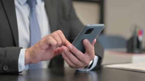 Close Up of Businessman Using Smartphone in Office
