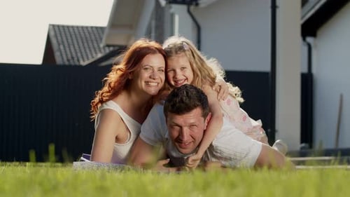 Happy Family Poses Together on Lawn