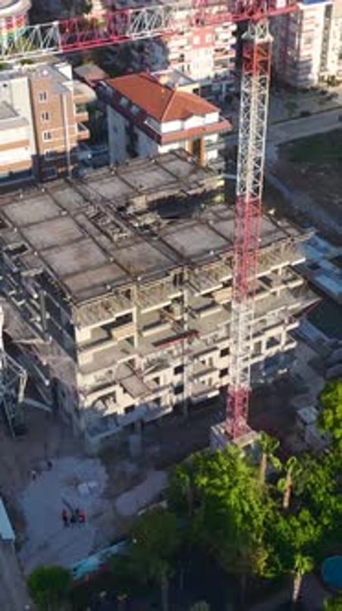Vídeo vertical de trabajadores en andamios preparando una estructura para pisos de concreto capturado verticalmente en