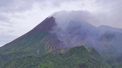Luftaufnahme des Gipfels des aktiven Vulkans Mount Merapi, der Rauch aus dem Krater ausstrahlt.