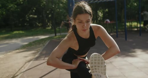 Fit Woman Stretching Outside in Park