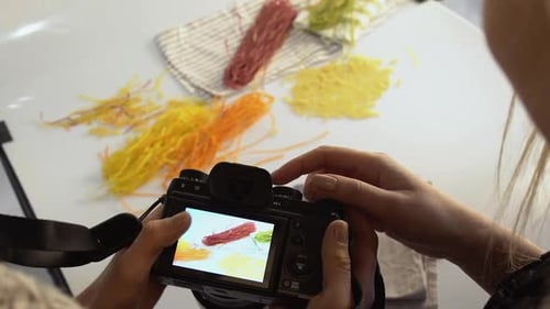 People Reviewing Food Photos on Camera