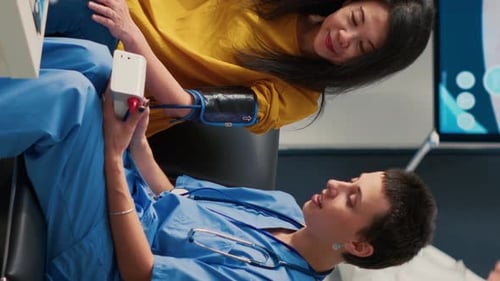 Healthcare Worker Checks Patient's Blood Pressure in Office