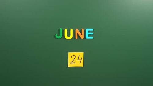 Hand sticking a sticker 24 June calendar day on school board. 24 date of June. Twenty fourth day