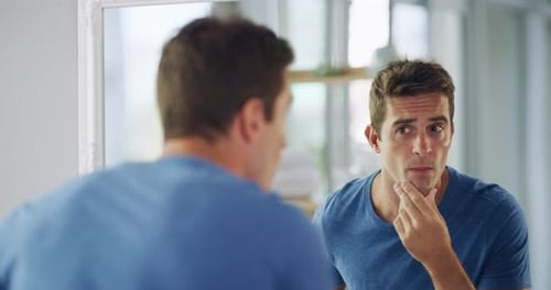 Schönheit, Pflege und Rasieren mit einem gutaussehenden Mann, der zu Hause sein Spiegelbild betrachtet