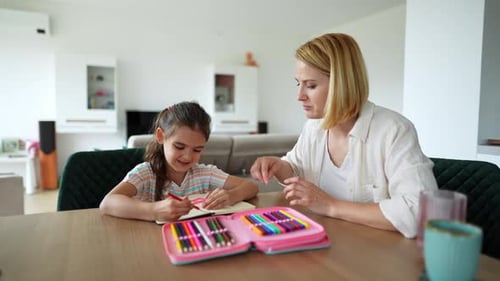 Child Drawing with Assistance from Woman in Bright Home