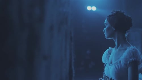 Cinematic shot of beautiful ballerina in ballet dress standing in theater hall and preparing to star