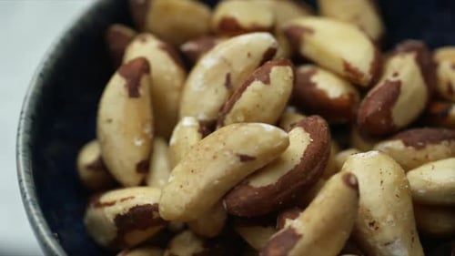 Brazil Nuts in a blue bowl. HD Shallow depth of field with pan across rotating bowl of nuts. Wholefo