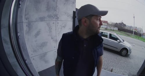 El mensajero masculino se comporta de manera grosera y agresiva mientras habla a través de una cámara de timbre inteligente