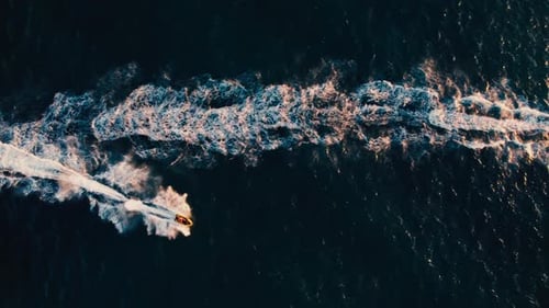 Two jet skies racing across a shimmering blue sea