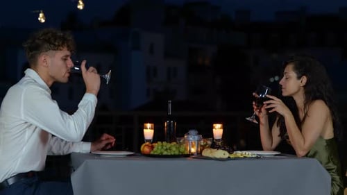 Couple Enjoying Romantic Dinner on Rooftop at Night