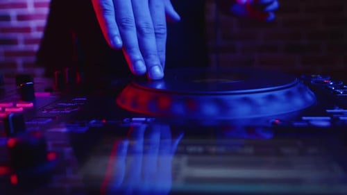 DJ arbeitet hinter der DJ-Station und drückt Tasten am Fader