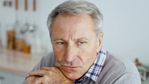 Senior Man Reflects on Life at Home in Cozy Atmosphere