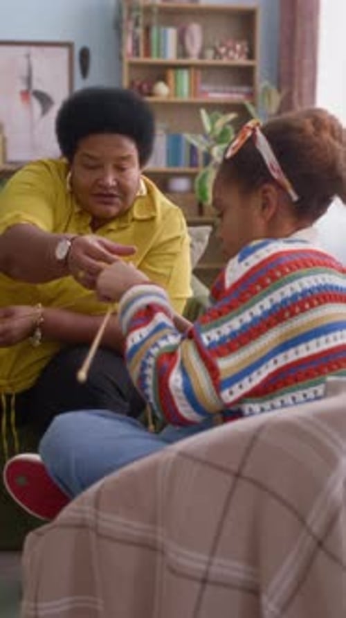 Woman Plays String Game with Child Indoors