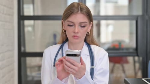 Female Doctor Using Cell Phone in Clinic
