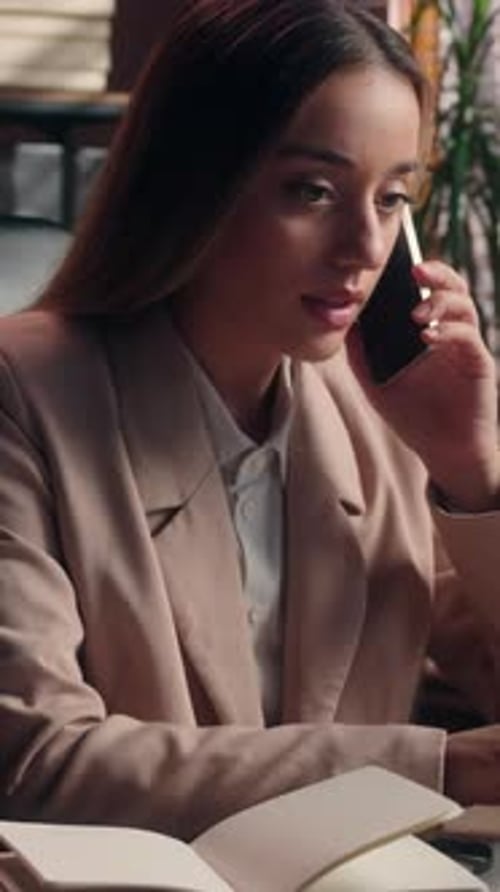 Woman Talking on Phone and Taking Notes