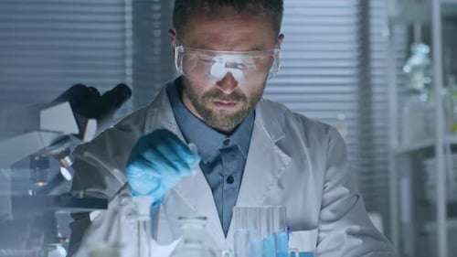 Scientist Using Pipette with Blue Liquid in Lab