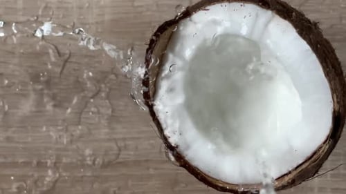Coconut water flowing out broken coconut.