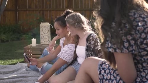 Teenage Girls Laughing Together Using a Mobile Phone