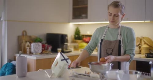 Woman Cracking Eggs for Baking in Kitchen