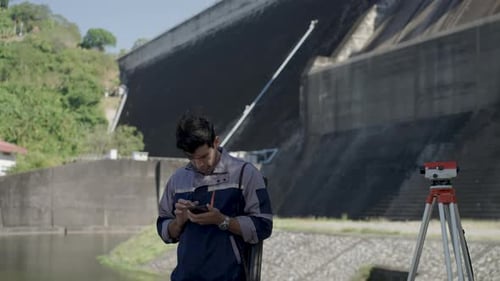 Blue collar worker is working at the dam.