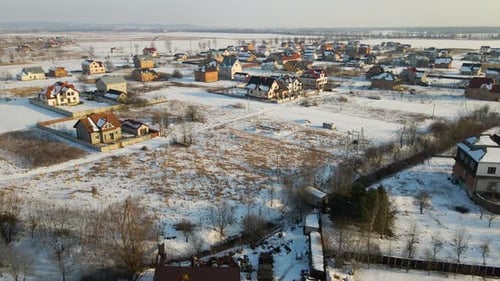 Aerial View of Private Homes with Snow Covered Roofs in Rural Suburbs Town Area in Cold Winter