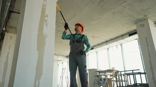 Pintor preparando paredes em um prédio em construção