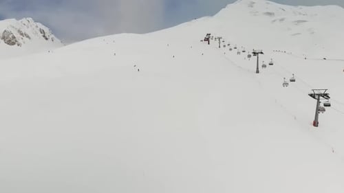 Aerial video of a cable car and people snowboarding and skiing
