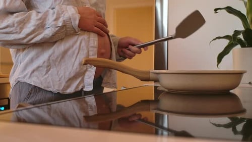 Femme préparant le petit déjeuner avec une bosse de bébé