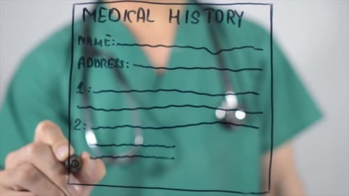 Medical Professional Writing Medical History on Glass