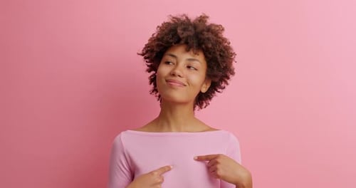 Smiling Woman Points at Herself in Studio