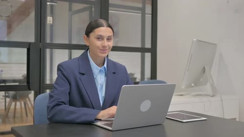 Businesswoman Working at Desk Giving Thumbs Up
